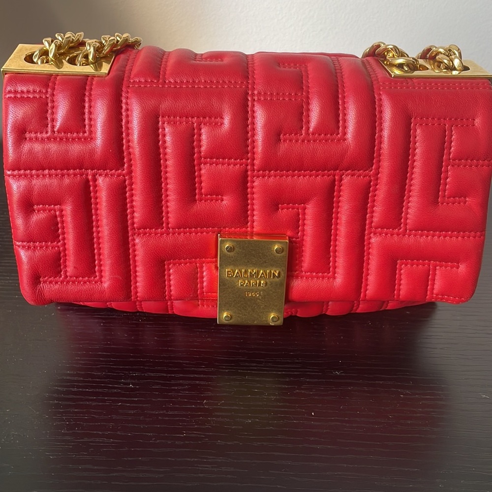 Balmain 1945 red quilted lambskin bag with gold accents.